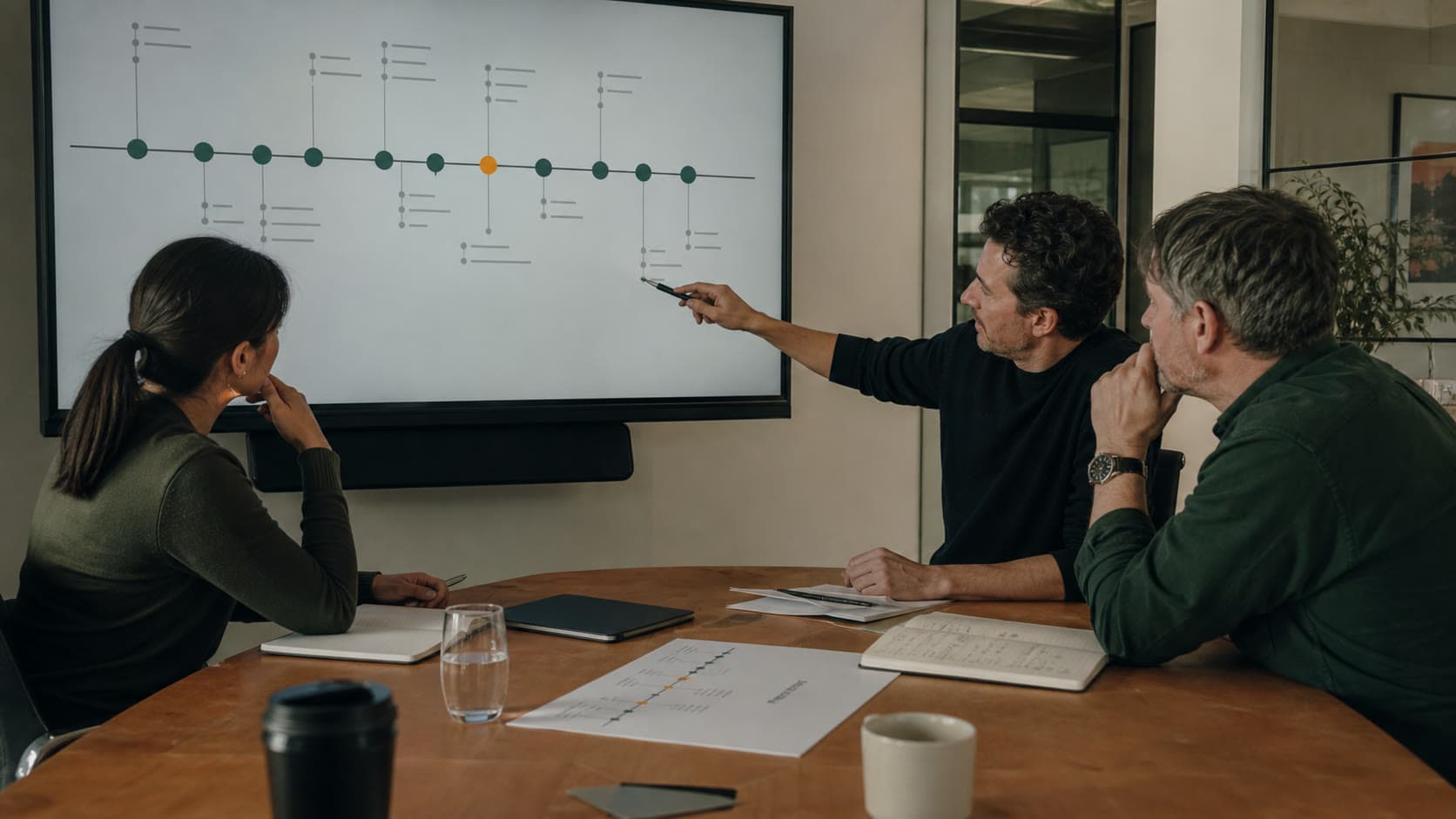 A business team examining a connected workflow map on a screen